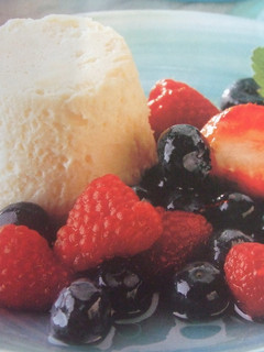 Una foto de Postre mantecado de plátano con frutas rojas en almíbar