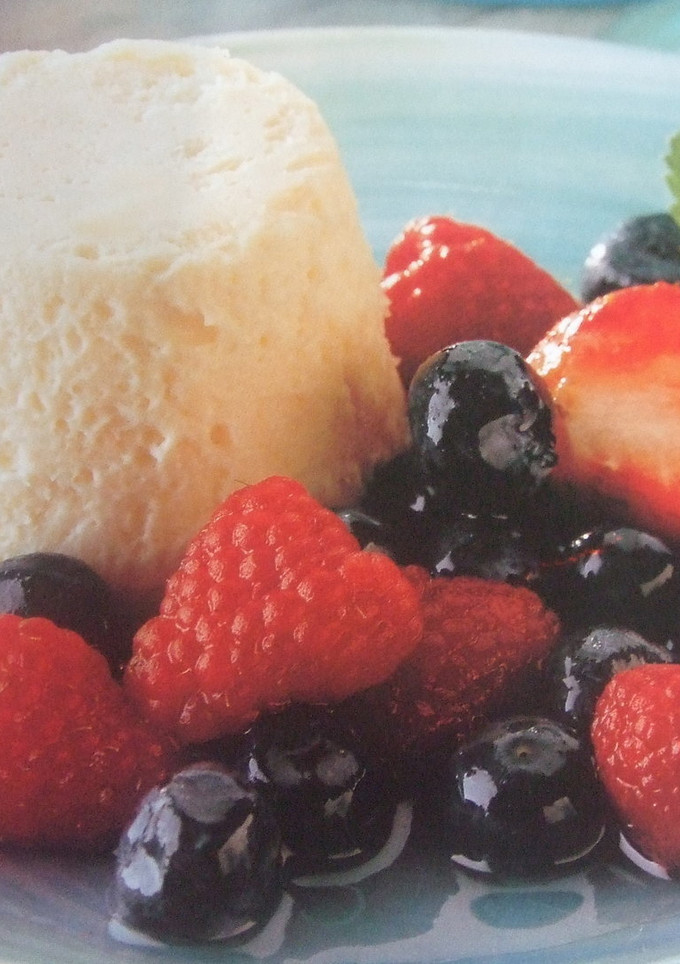 Una foto de Postre mantecado de plátano con frutas rojas en almíbar