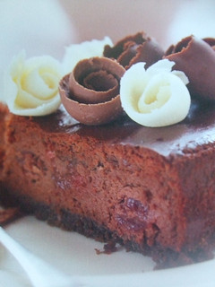 Una foto de Tarta de tres chocolates con cerezas y nueces