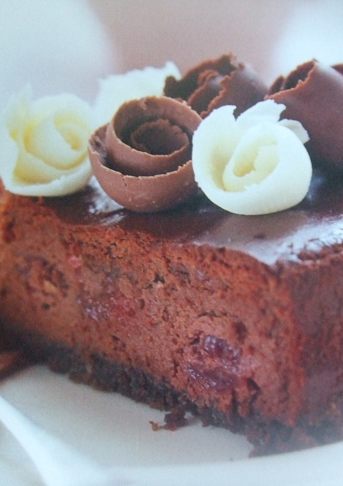 Una foto de Tarta de tres chocolates con cerezas y nueces