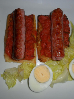 Una foto de Salchicha de cerdo sobre tostadas con vinagreta de tomates frescos