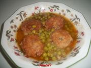 Una foto de albóndigas con salsa con arvejas