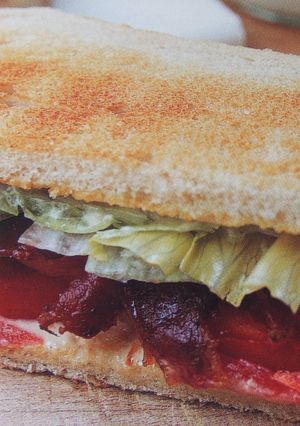 Una foto de Sándwich tostado de bacón ahumado con tomate y lechuga