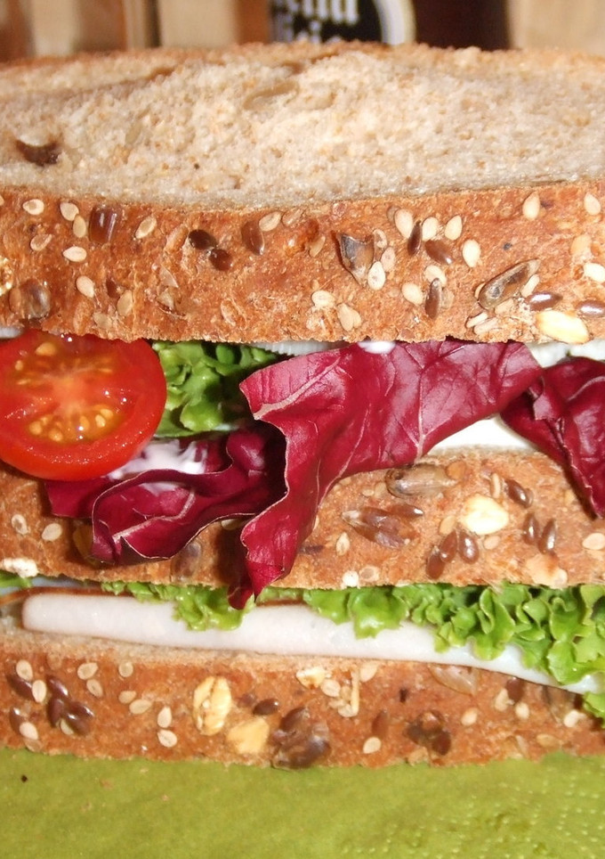 Una foto de Sándwich triple de pavita y queso con verduras