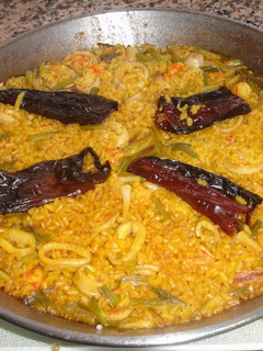 Una foto de Paella de gambones con calamares frescos y ajos tiernos