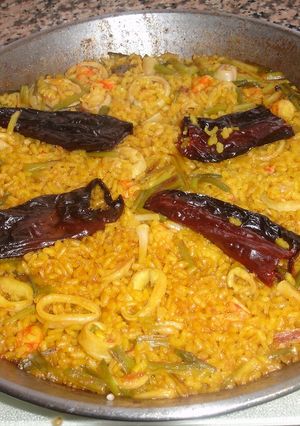 Una foto de Paella de gambones con calamares frescos y ajos tiernos