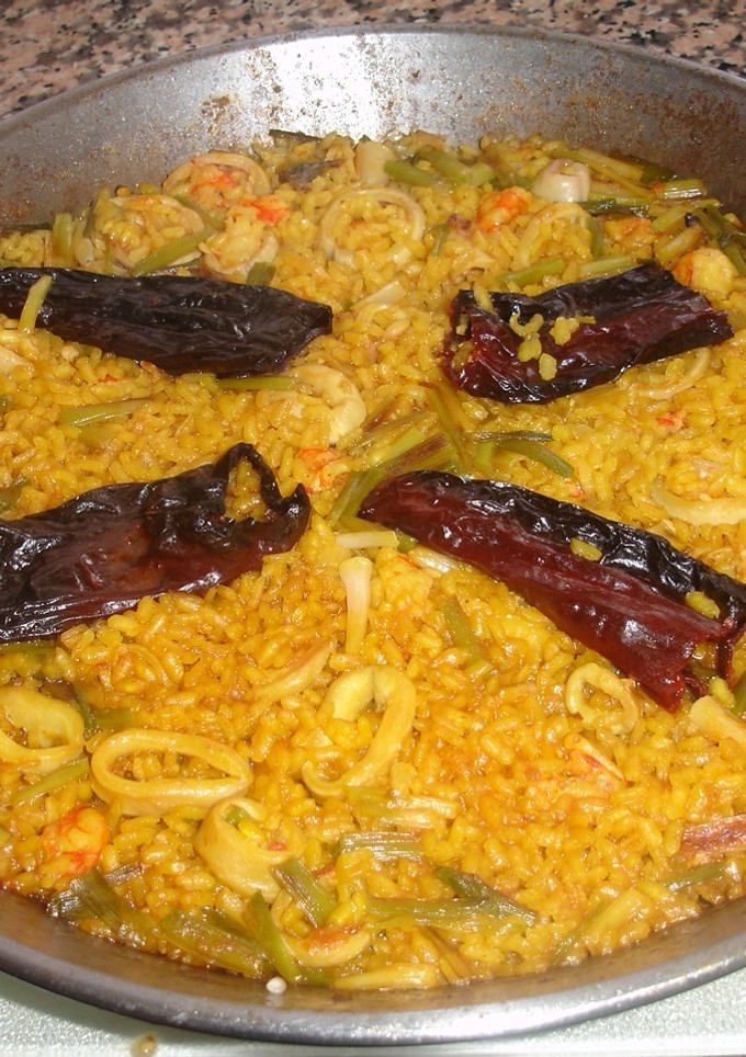Una foto de Paella de gambones con calamares frescos y ajos tiernos