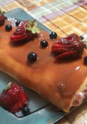 Una foto de Arrollado de crema frutillas y arándanos