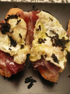 Una foto de Tostada de jamón ibérico y huevo de perdiz con trufa