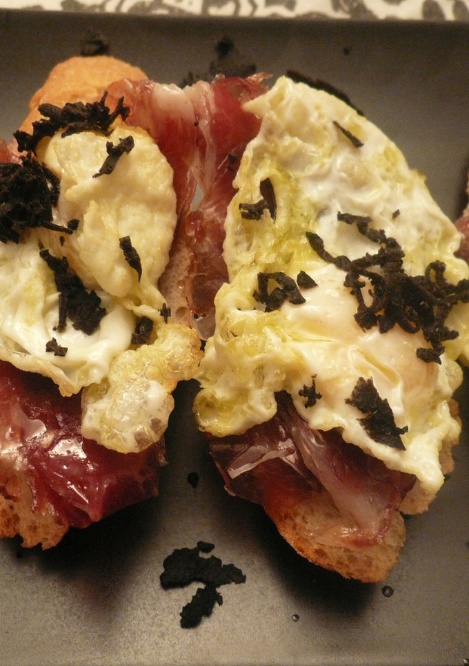 Una foto de Tostada de jamón ibérico y huevo de perdiz con trufa