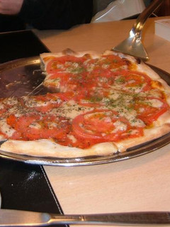 Una foto de Pizza con tomates frescos y albaca