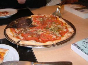 Una foto de Pizza con tomates frescos y albaca