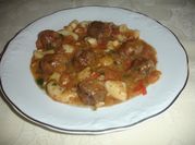 Una foto de carne deshebrada con cebolla y tomate