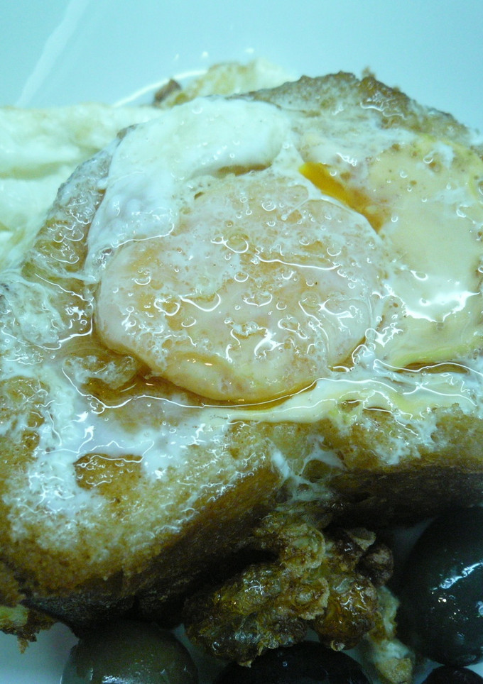 Una foto de Pan con huevo frito y aceitunas