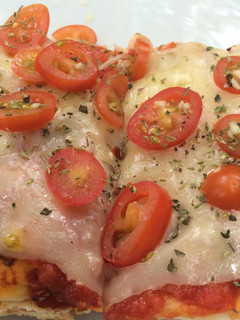 Una foto de Pizza a la parrilla con tomates y mozzarella