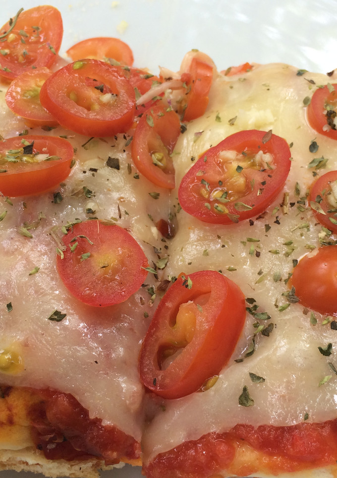 Una foto de Pizza a la parrilla con tomates y mozzarella