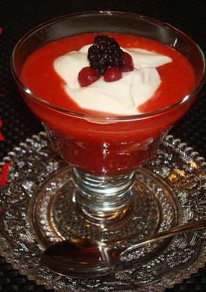 Una foto de Postre de crema de queso y salsa de fresones