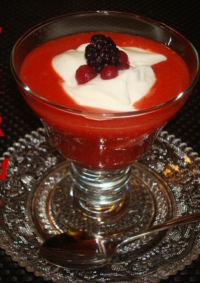 Una foto de Postre de crema de queso y salsa de fresones