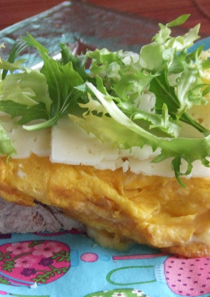 Una foto de Tostada con tortilla de atún, queso y escarola
