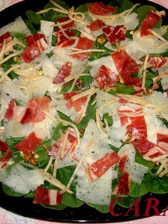 Una foto de Ensalada de espinacas, con jamón ibérico, queso laminado y nueces