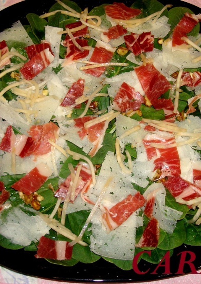 Una foto de Ensalada de espinacas, con jamón ibérico, queso laminado y nueces