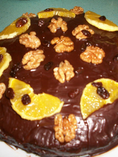 Una foto de Tarta de chocolate con crema de naranja, nata y nueces