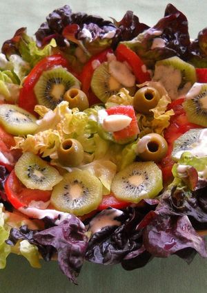 Una foto de Ensalada de lechuga hoja de roble y kiwis con salsa de queso y ajo