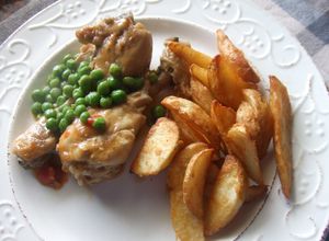Foto principal de Muslitos de pollo guisados con guisantes y gajos de patatas