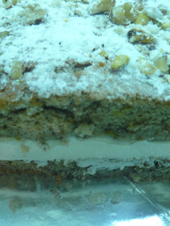 Una foto de Tarta de nueces, pistachos, emborrachada y rellena de nata