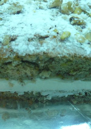 Una foto de Tarta de nueces, pistachos, emborrachada y rellena de nata