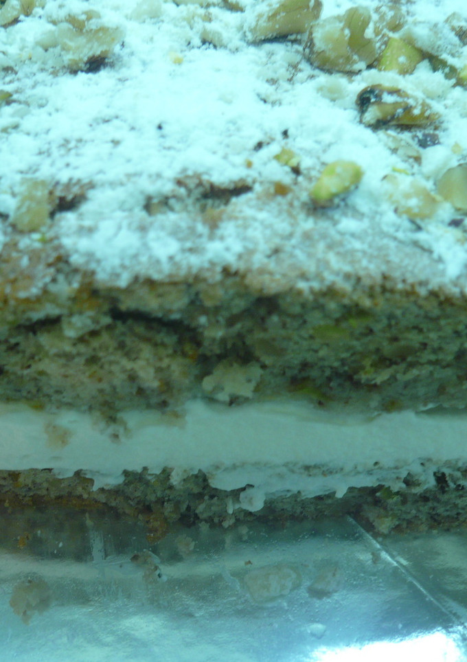 Una foto de Tarta de nueces, pistachos, emborrachada y rellena de nata
