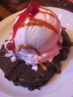 Una foto de Brownie con helado y salsa de chocolate