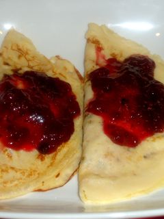 Una foto de Crepes rellenos de queso ricotta con salsas de agraz y de arándanos