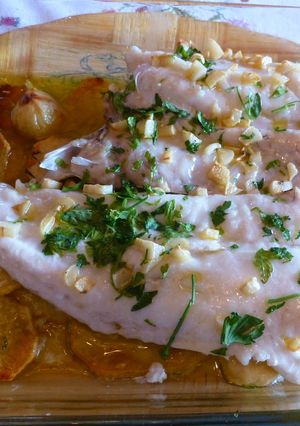 Una foto de Merluza al horno con ajitos, perejil y patatas panaderas