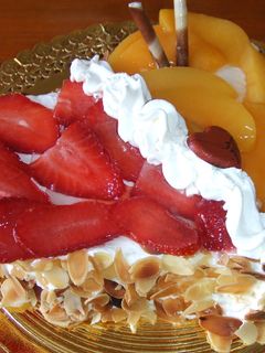 Una foto de Corazón almendrado de nata con fresas y melocotones