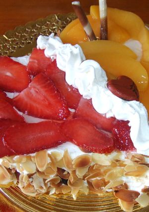 Una foto de Corazón almendrado de nata con fresas y melocotones