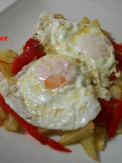 Una foto de Patatas fritas con pimiento rojo asado y huevos fritos con salsa de ajitomate