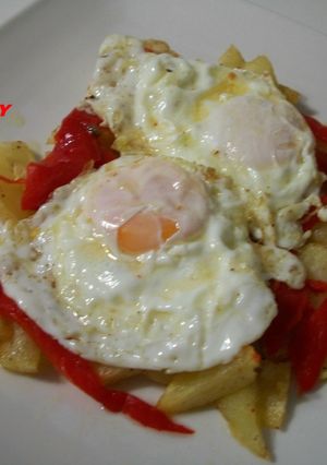 Una foto de Patatas fritas con pimiento rojo asado y huevos fritos con salsa de ajitomate