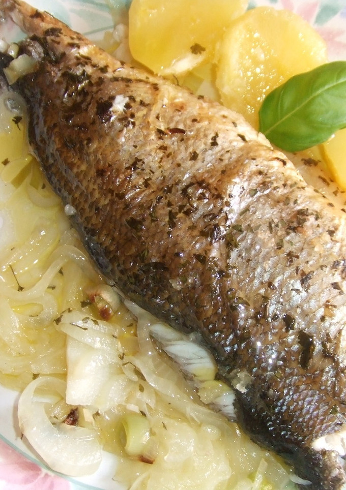 Una foto de Lubina encebollada al orégano con patatas al aceite de uva