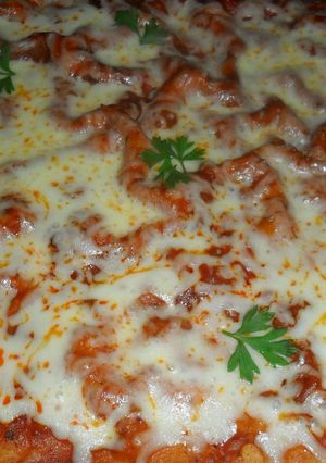 Una foto de Pizza casera con tomate y queso