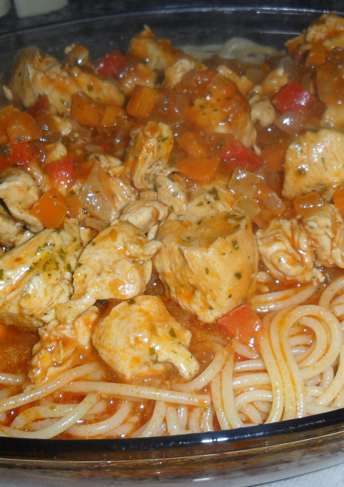 Una foto de Tallarines con pollo en salsa natural de tomate al ajo y perejil