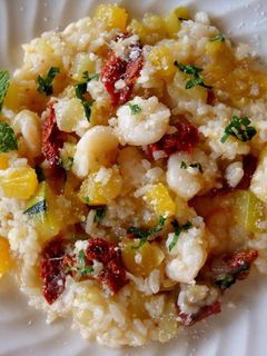 Una foto de Risotto de calabaza amarilla, tomates secos y gambas