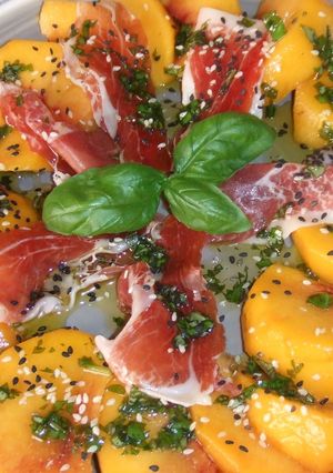 Una foto de Ensalada de melocotón con jamón de Parma y semillas