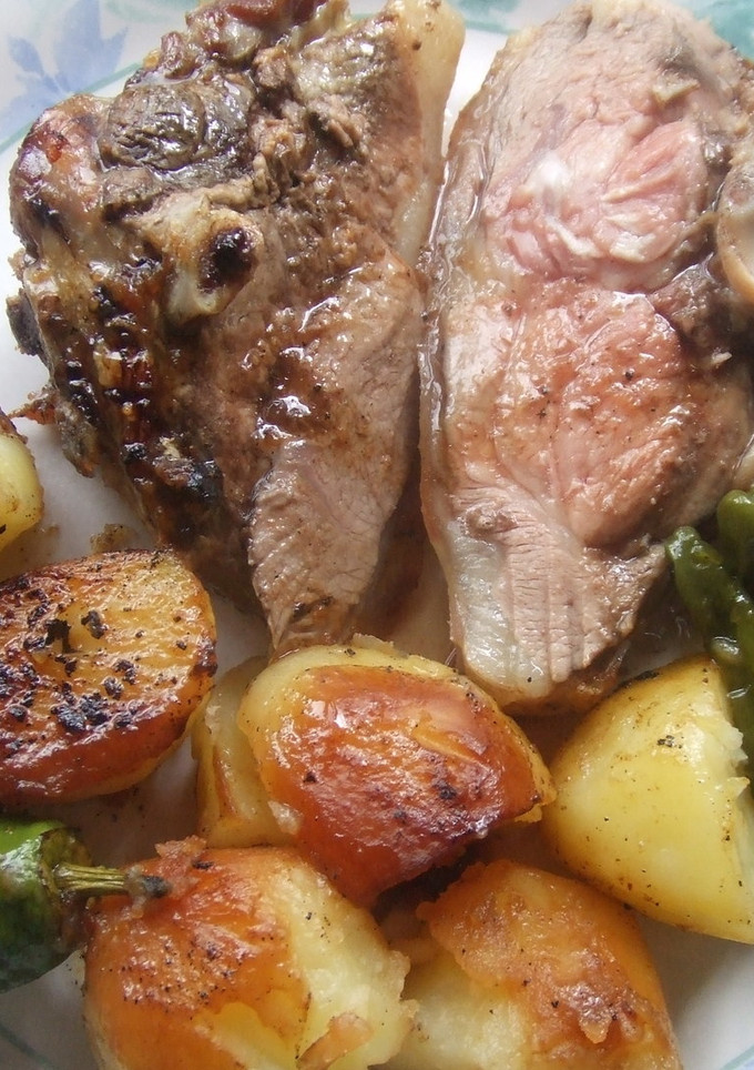 Una foto de Pierna de cordero asada al laurel con pimientos de Padrón