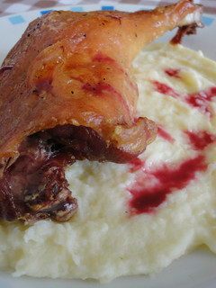 Una foto de Confit de pato con puré de patata y salsa de frutos rojos