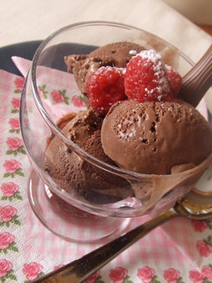 Una foto de Helado de chocolate con trocitos y frambuesas
