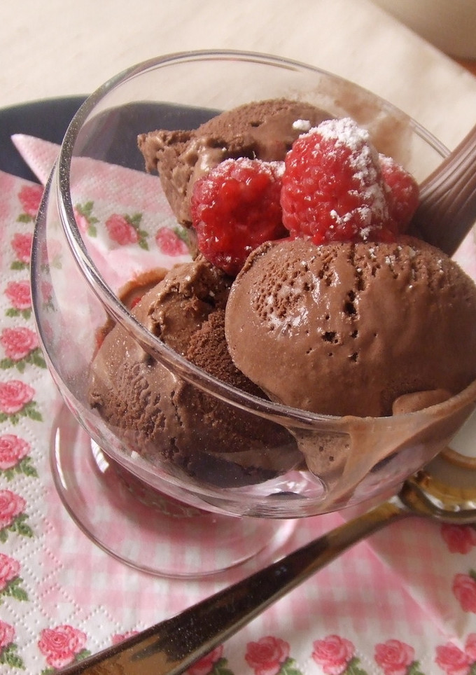 Una foto de Helado de chocolate con trocitos y frambuesas