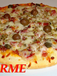 Una foto de Pizza de jamón ibérico, jamón york y queso
