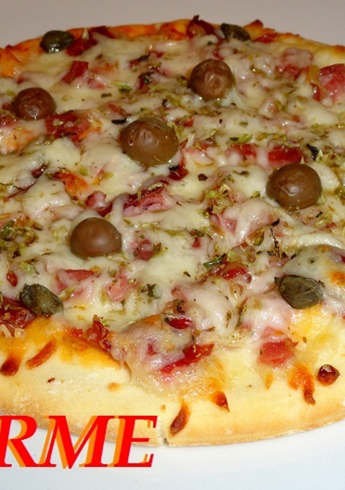 Una foto de Pizza de jamón ibérico, jamón york y queso