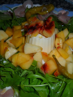 Una foto de Ensalada de rúcula con jamón, queso y frutas